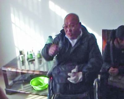 老孟坐在轮椅上和民警交流。